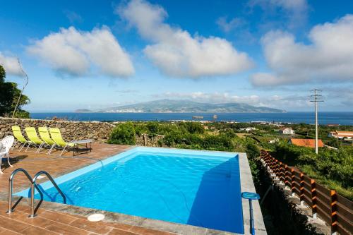 a swimming pool with a view of the ocean at Adega da Quinta - Casa da Gigi in Madalena