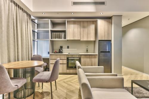 uma cozinha e sala de jantar com mesa e cadeiras em WINK Aparthotel One Thibault na Cidade do Cabo