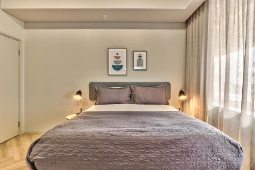 a bedroom with a large bed and two lamps at WINK Aparthotel One Thibault in Cape Town