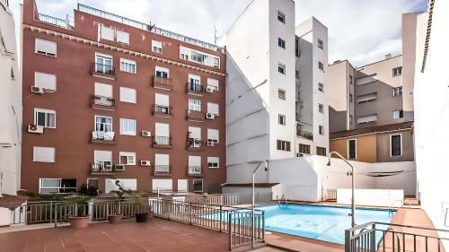 a building with a swimming pool in front of a building at Plaza Mayor II - Apartamento de 2 dormitorios in Madrid