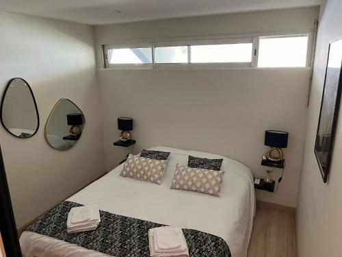 niewielka sypialnia z 2 łóżkami i 2 lustrami w obiekcie The Wave Village Naturiste Port Ambonne Cap d Agde w Cap d'Agde