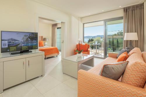 a living room with a couch and a television at Rodostamo Hotel & Spa- Adults Friendly in Kommeno