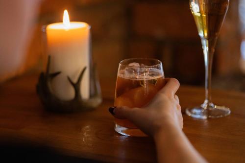a person holding a glass of wine and a candle at The Haughmond in Shrewsbury