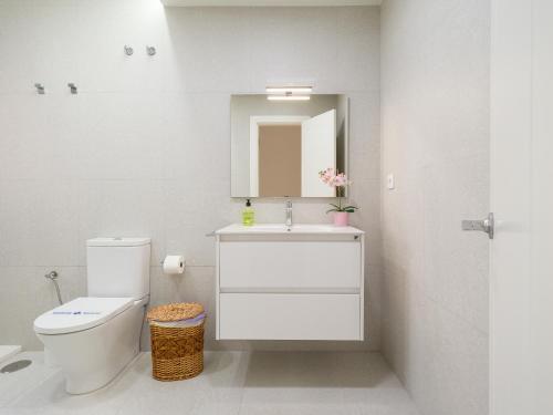 une salle de bain avec toilettes, lavabo et miroir dans l'établissement Meloneras Ocean Escape by CanaryScape, à San Bartolomé