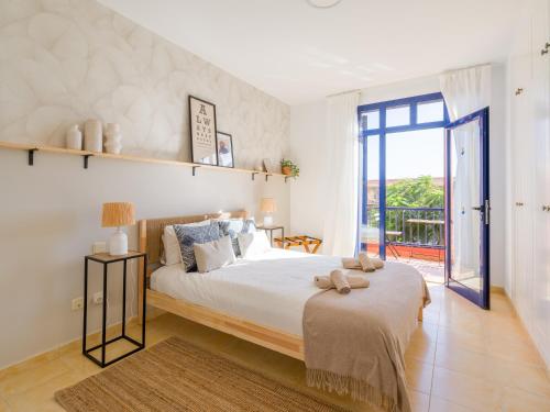 une chambre avec un grand lit et un balcon dans l'établissement Meloneras Ocean Escape by CanaryScape, à San Bartolomé
