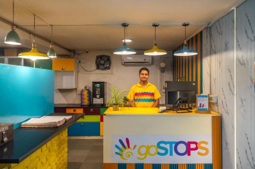 a man standing behind a counter in a colorful kitchen at goSTOPS Delhi in New Delhi