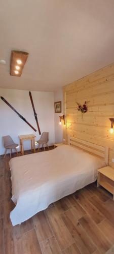 a bedroom with a large white bed and wooden walls at Willa Julia in Ustroń