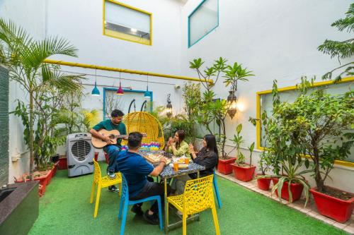 a group of people sitting at a table in a garden at goSTOPS Delhi in New Delhi