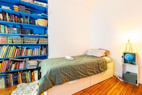 - une chambre avec un lit et une étagère avec des livres dans l'établissement GuestReady - Loveliness near Pont Mirabeau, à Paris