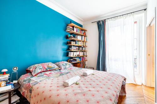 - une chambre bleue avec un lit et une étagère dans l'établissement GuestReady - Loveliness near Pont Mirabeau, à Paris