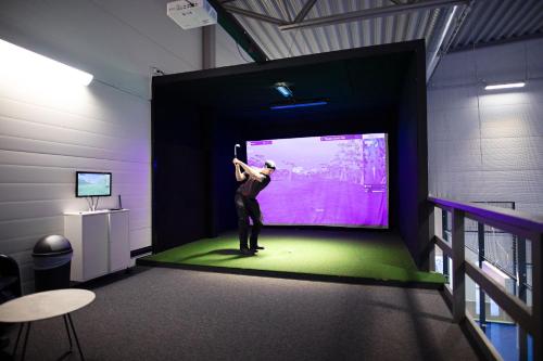 a woman standing on a stage in a room with a projection screen at Camp Ripan in Kiruna