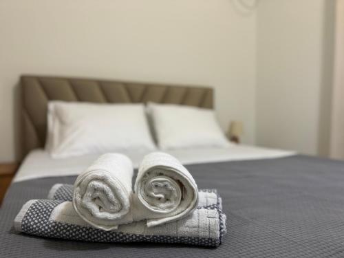 a pile of towels sitting on top of a bed at Angelo Agapi Rooms Vlore in Vlorë