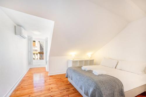 um quarto branco com uma cama e uma janela em GuestReady - B-MAD Museum At Your Doorstep em Lisboa