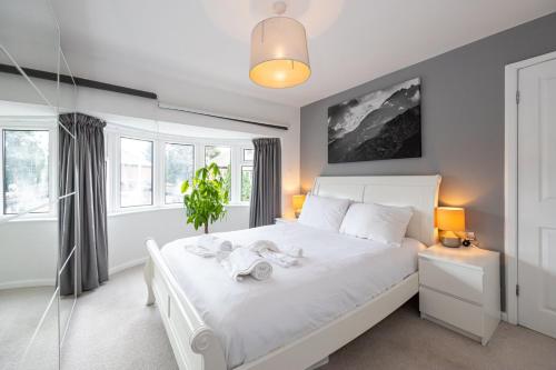 een slaapkamer met een wit bed en 2 handdoeken bij GuestReady - Tranquil Retreat near Bramall Hall in Cheadle
