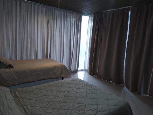 um quarto com uma cama e uma janela com cortinas em Lujan Homes em Luján