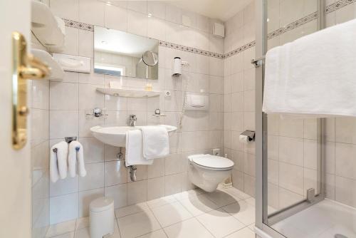 bagno bianco con servizi igienici e lavandino di Gästehaus Daheim a Riezlern