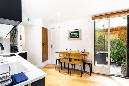 une cuisine et une salle à manger avec une table et des chaises dans l'établissement GuestReady - Serene stay near Champ de Mars, à Paris