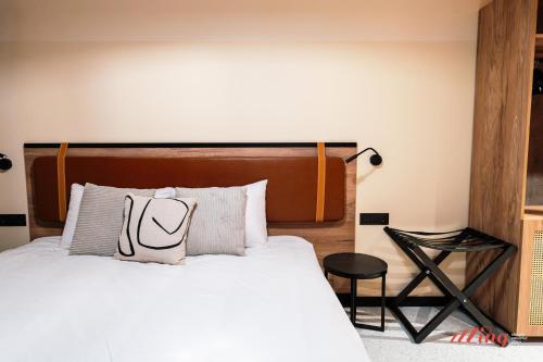 a bedroom with a white bed with a wooden headboard at Stuart Rooms by Zzzing in Il-Gżira