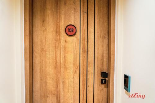 a wooden door with a clock on it at Stuart Rooms by Zzzing in Il-Gżira