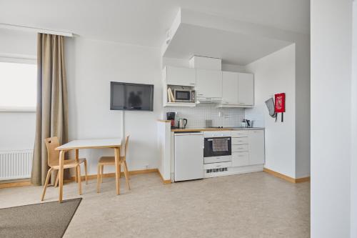 a kitchen with white cabinets and a table and chairs at Töölö Towers in Helsinki