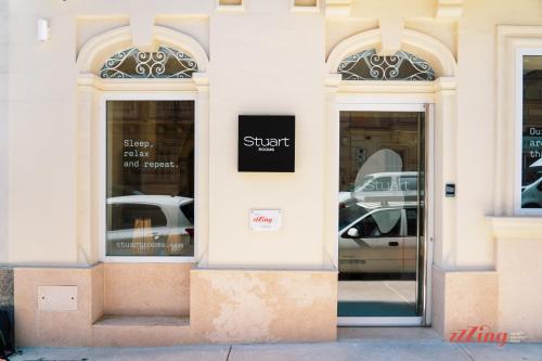 a store front with two doors with a sign on it at Stuart Rooms by Zzzing in Il-Gżira