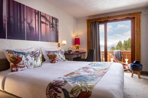 um quarto de hotel com uma cama e uma varanda em Hôtel Courcheneige em Courchevel