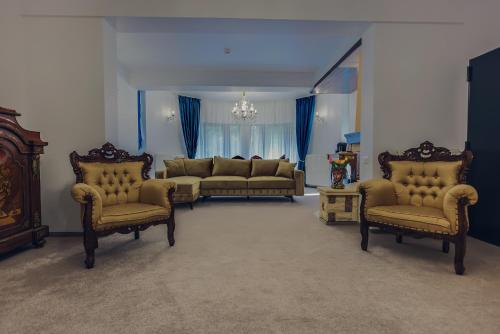 a living room with couches and chairs in a room at Villa Tom in Sinaia