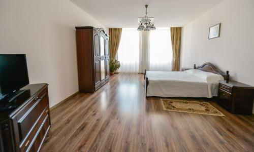 a bedroom with a bed and a flat screen tv at Le Petit Paris in Cluj-Napoca