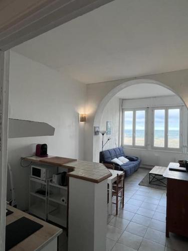 a kitchen and living room with a table and a couch at Maison sur mer in Palavas-les-Flots