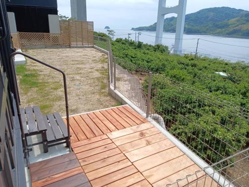 a balcony with a wooden deck with a view of the water at nagi-setouchi in Kure