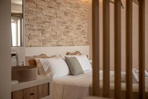 um quarto com uma cama e uma parede de tijolos em Chrissida Hotel em Nea Kydonia