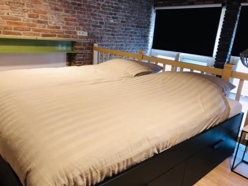 a bed in a room with a brick wall at Hotel de Prince in Nijmegen
