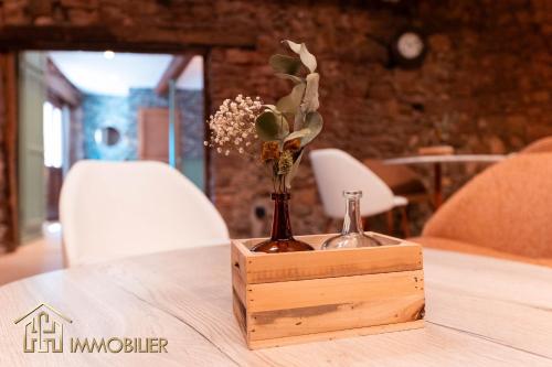 a wooden box with a vase of flowers on a table at Chez Hansi & Emmy - Gueberschwihr in Gueberschwihr