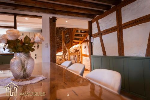 a table with chairs and a vase with flowers on it at Chez Hansi & Emmy - Gueberschwihr in Gueberschwihr