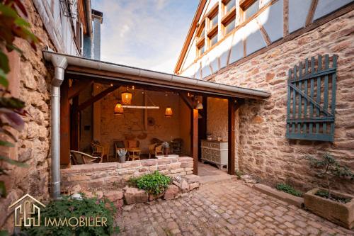 a stone building with a patio and a building at Chez Hansi & Emmy - Gueberschwihr in Gueberschwihr