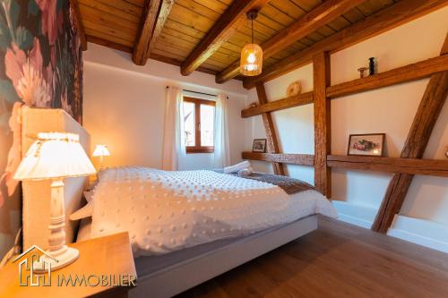 a bedroom with a bed in a room with wooden ceilings at Chez Hansi & Emmy - Gueberschwihr in Gueberschwihr