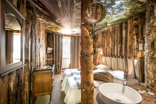 a bathroom with a bed and a sink in a room at Hotel Le Rocher Blanc in Albaret-Sainte-Marie