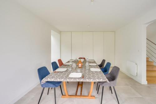 a dining room with a table and blue chairs at Maison familiale tout pres des plages a Loctudy in Loctudy