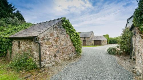 an old stone building on the side of a road at Ty Poeth in Brynsiencyn