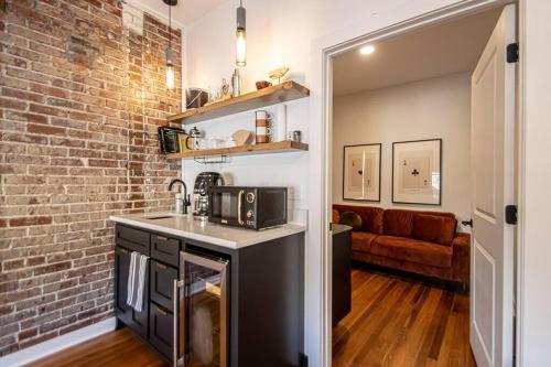 a kitchen with a sink and a brick wall at Steps to Bathhouses, Historic Downtown Apartment Room # 201 in Hot Springs