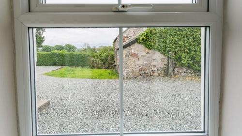 an open window with a view of a yard at Ty Poeth in Brynsiencyn