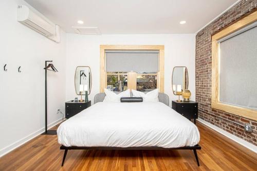a bedroom with a white bed and a brick wall at Steps to Bathhouses, Historic Downtown Apartment Room # 201 in Hot Springs