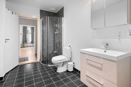 a white bathroom with a toilet and a shower at Forenom Serviced Apartments Oslo Nobel in Oslo