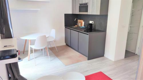 - une petite cuisine avec une table et des chaises blanches dans l'établissement Centre ville delille 19, à Nice