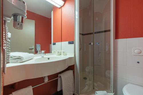 a bathroom with a sink and a shower at Ace Hotel Chateauroux Déols in Déols