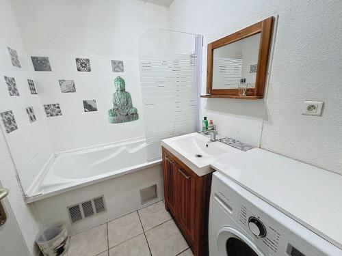 une salle de bain avec un lavabo et une machine à laver dans l'établissement Jaurès cœur de ville, à Sète