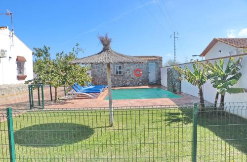 a villa with a swimming pool and a fence at Alnoa II in Roche