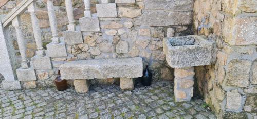 a stone bench sitting next to a stone wall at Stone House in Salzedas