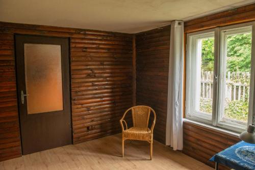 a chair sitting in a room with a window at Przytulny domek na wsi in Natać Wielka