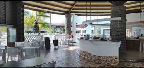 een restaurant met een bar en tafels en stoelen bij Studio kassav in Saint-François